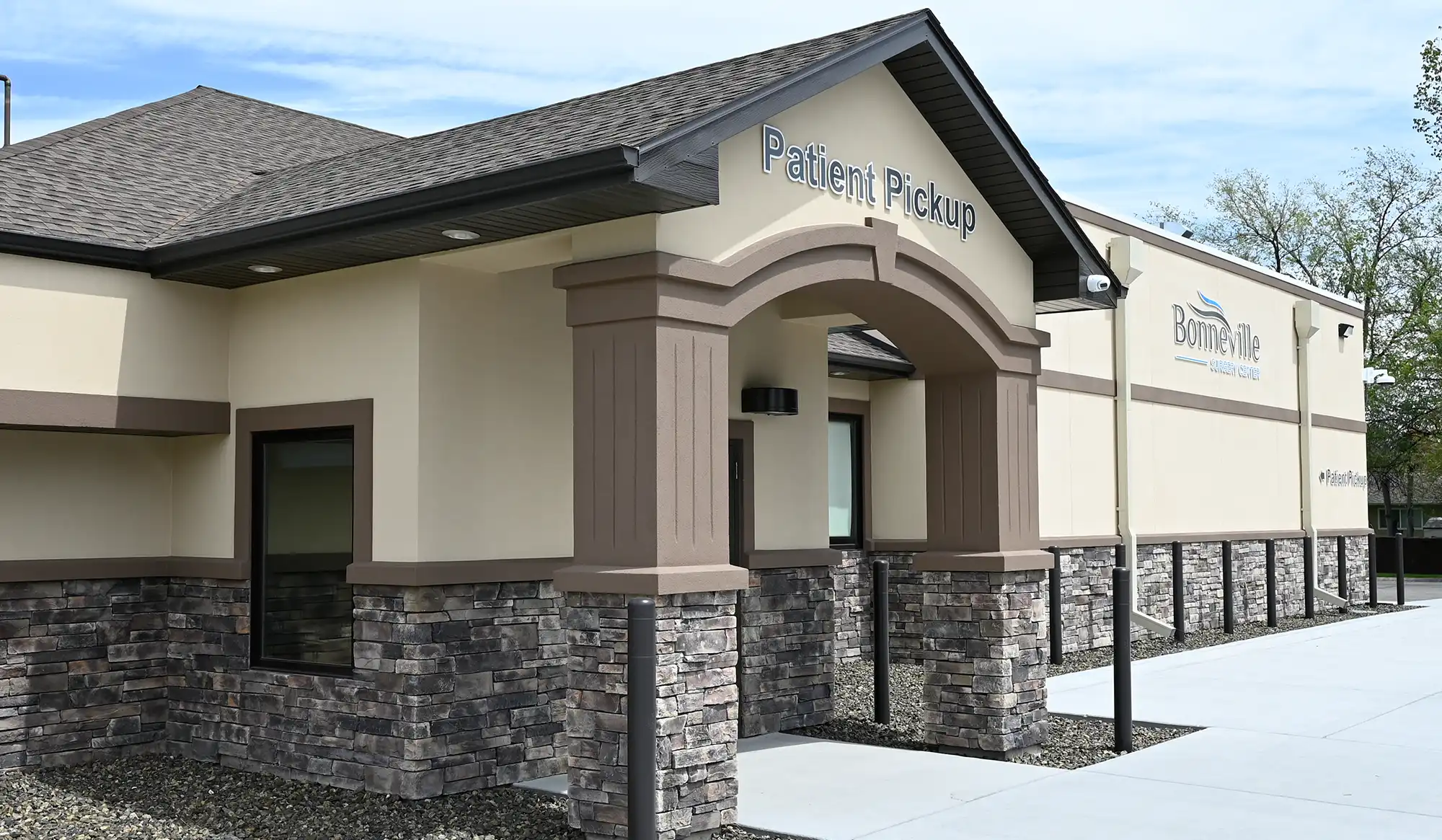 Exterior of the Bonneville Surgery Center building, showing a covered "Patient Pickup" entryway supported by stone columns and beige stucco walls.
