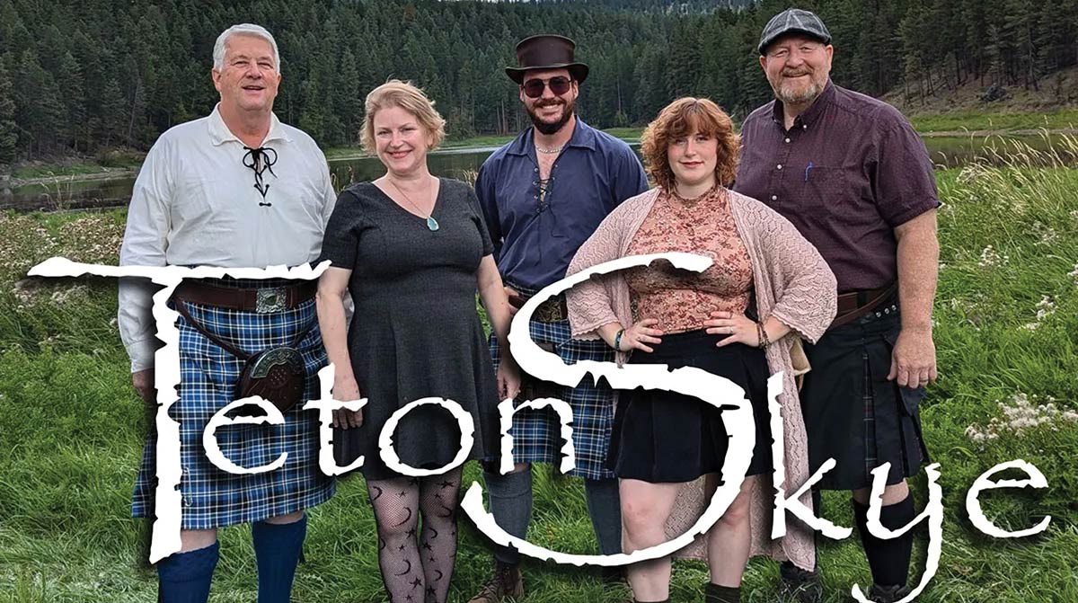 Five people smile in a grassy field with a lake and pine forest in the background. The men wear kilts, and the group stands behind a large, stylized white text overlay that reads "Teton Skye."
