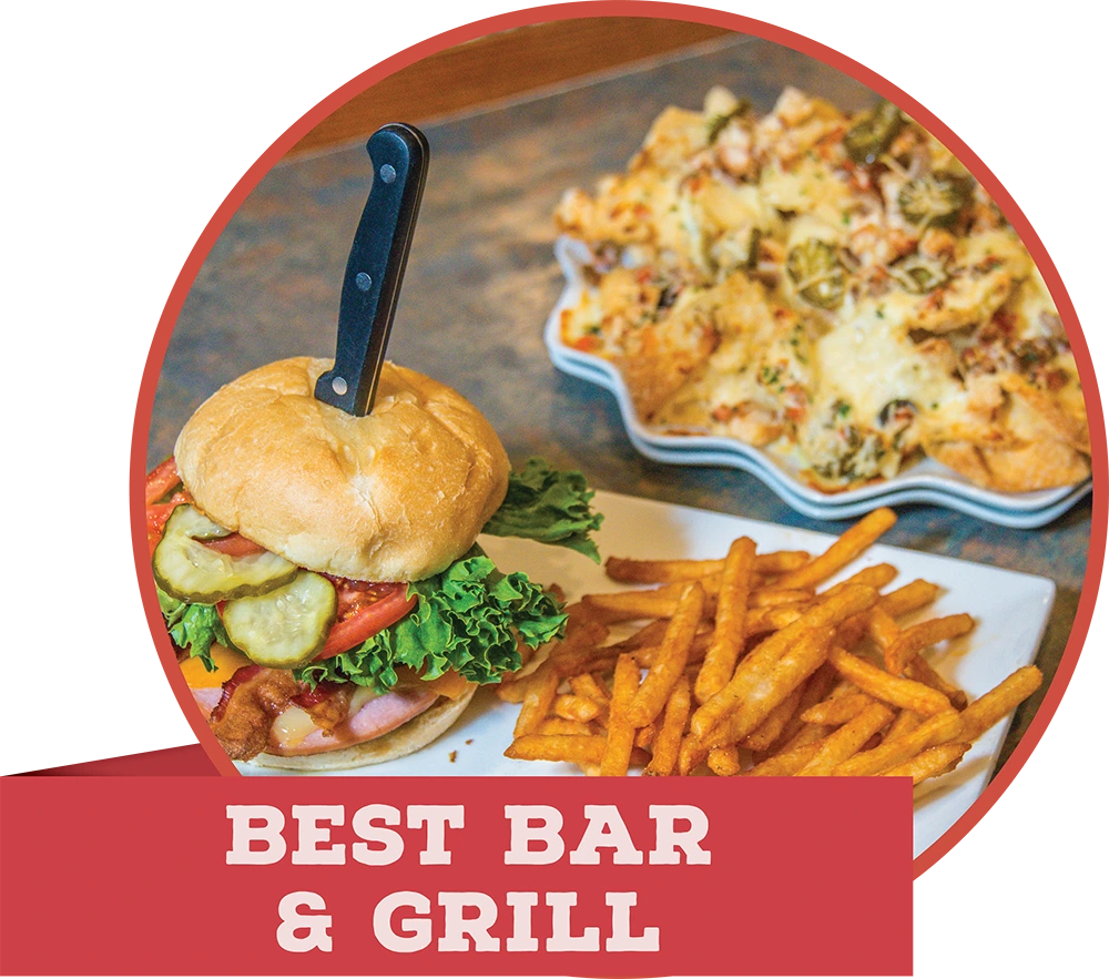 A loaded bacon cheeseburger pinned with a knife, served with fries, featuring a red banner that reads "BEST BAR & GRILL."