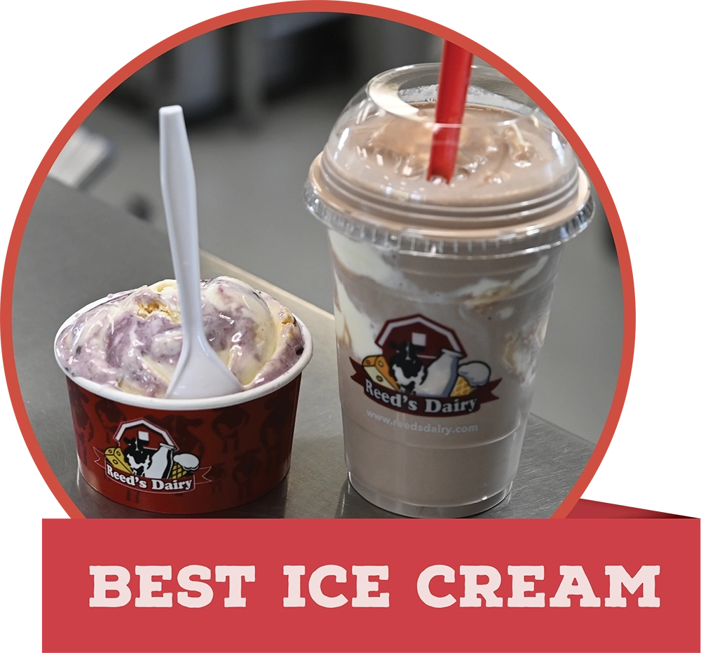 A cup of swirled ice cream and a milkshake from Reed's Dairy on a counter, with a red banner reading "BEST ICE CREAM."